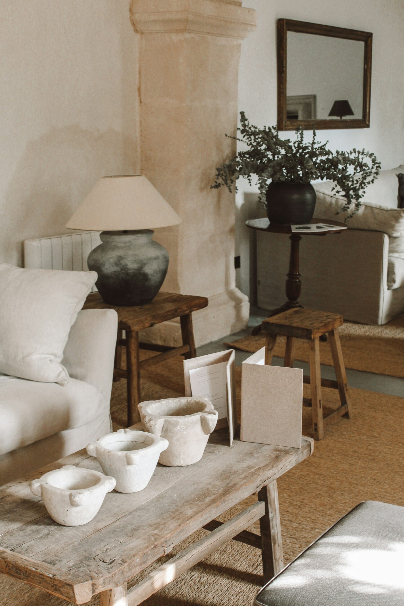 A quiet corner with a paper lamp, wooden stool and a stoneware vase