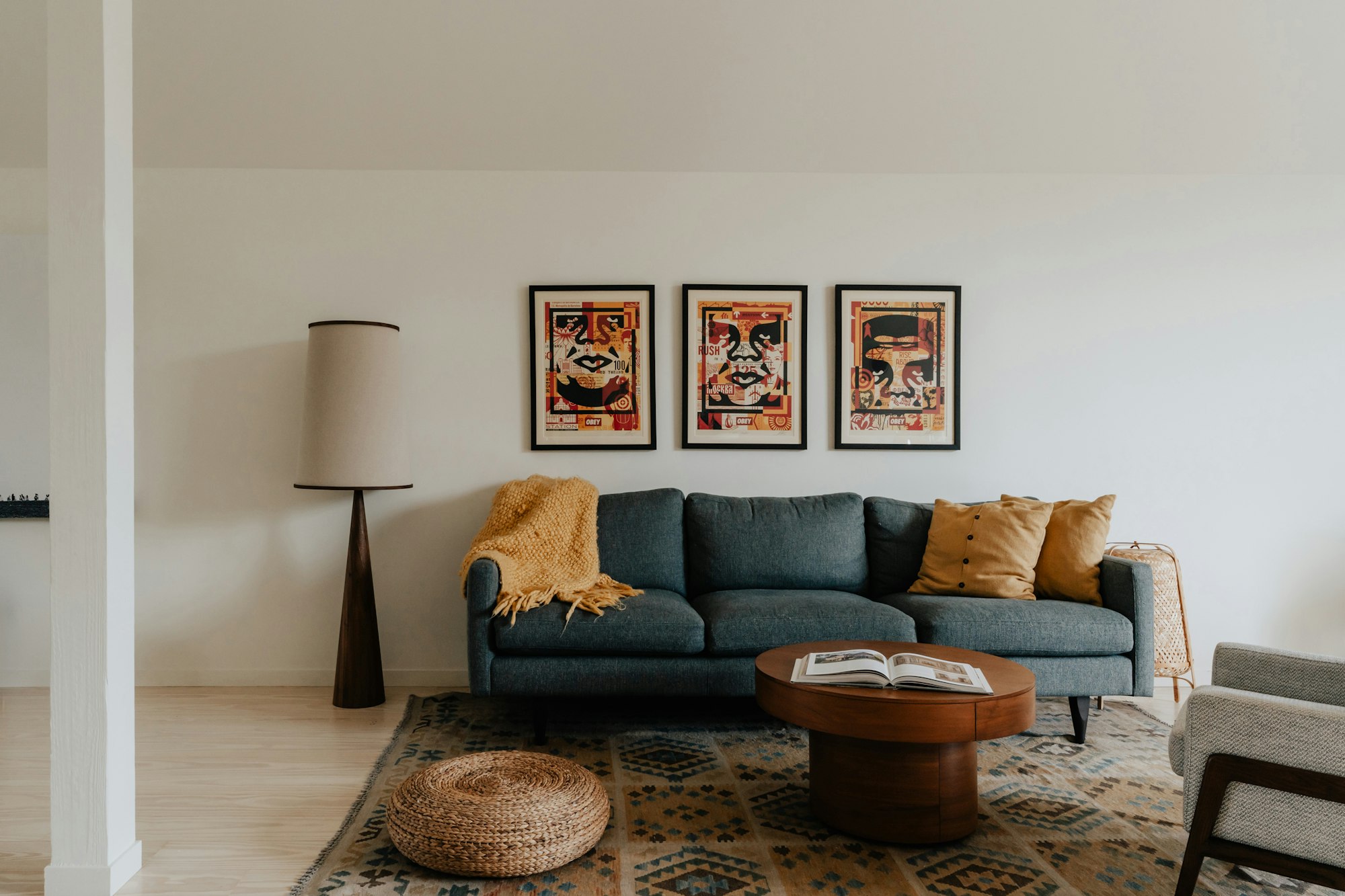 A bright living room with a round rattan mirror, jute rug and linen sofa